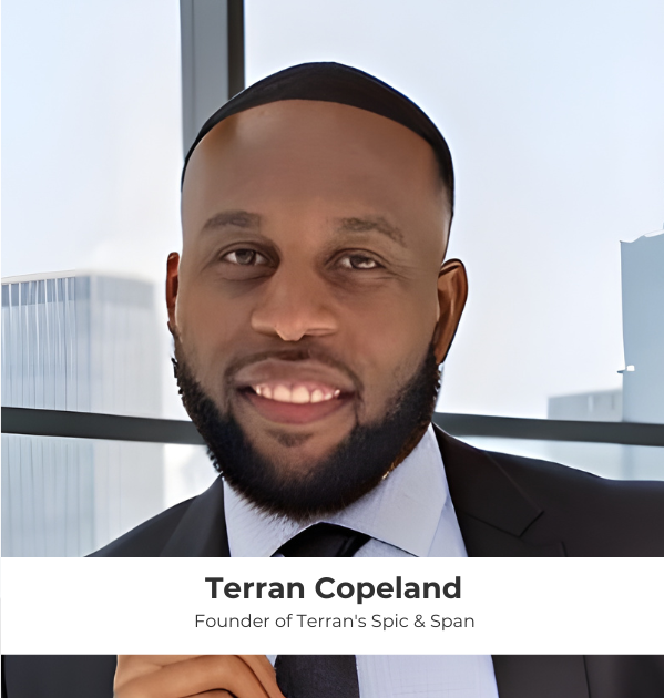 A portrait of Terran Copeland, the founder of Terran's Spic & Span, smiling and wearing a suit, with a modern office building backdrop.