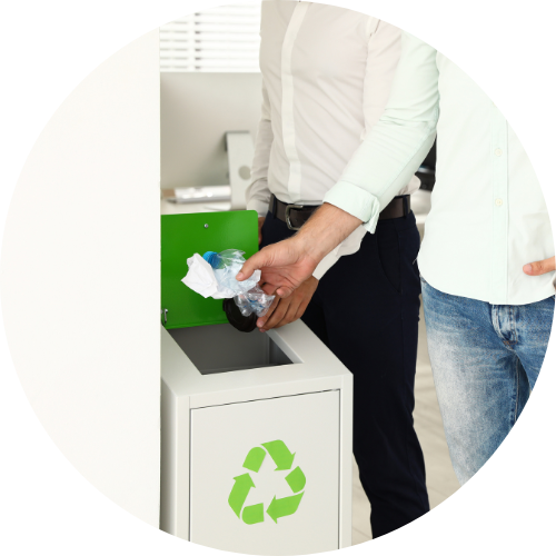 Young men throwing garbage into recycling bin in the office