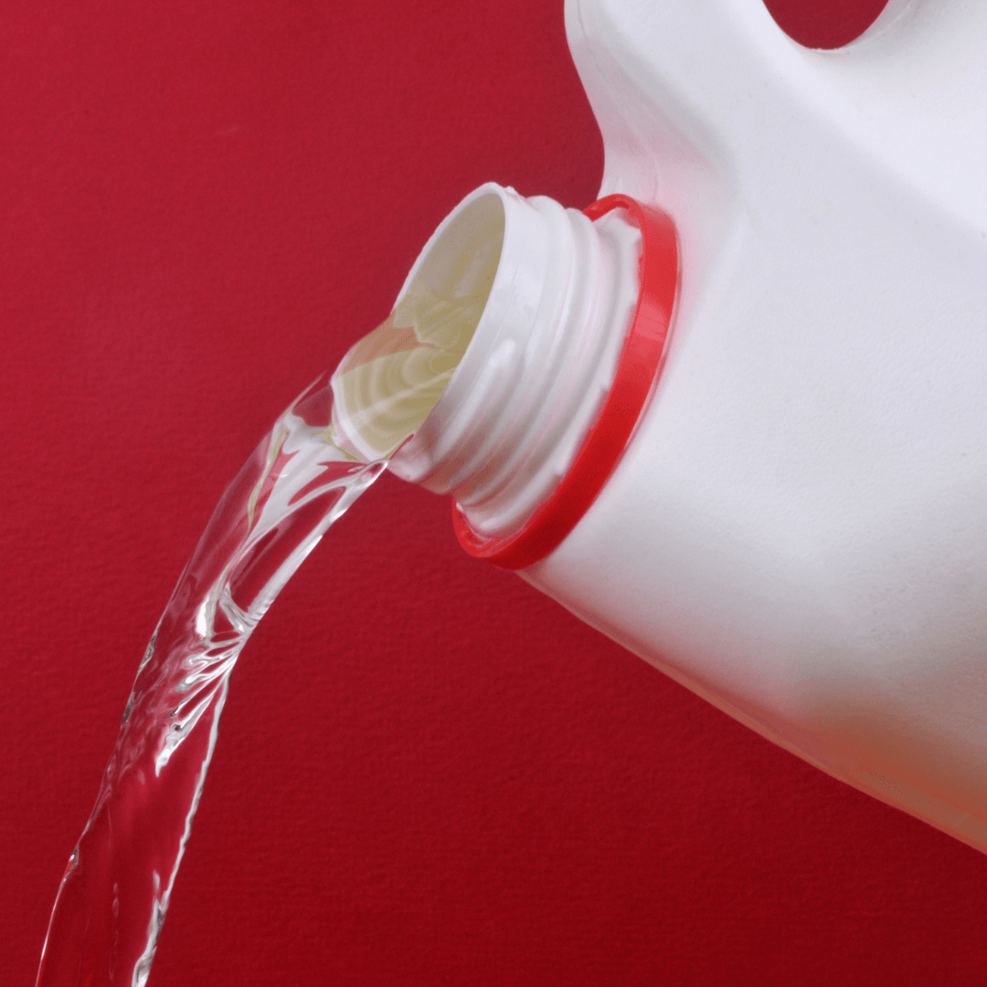 Bleach being poured with red background