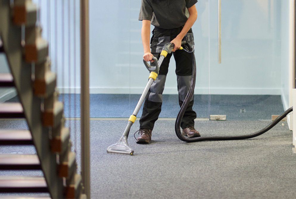 professional cleaner vacuuming office carpet