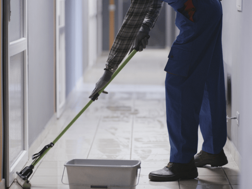 Janitor mopping a school hallway floor