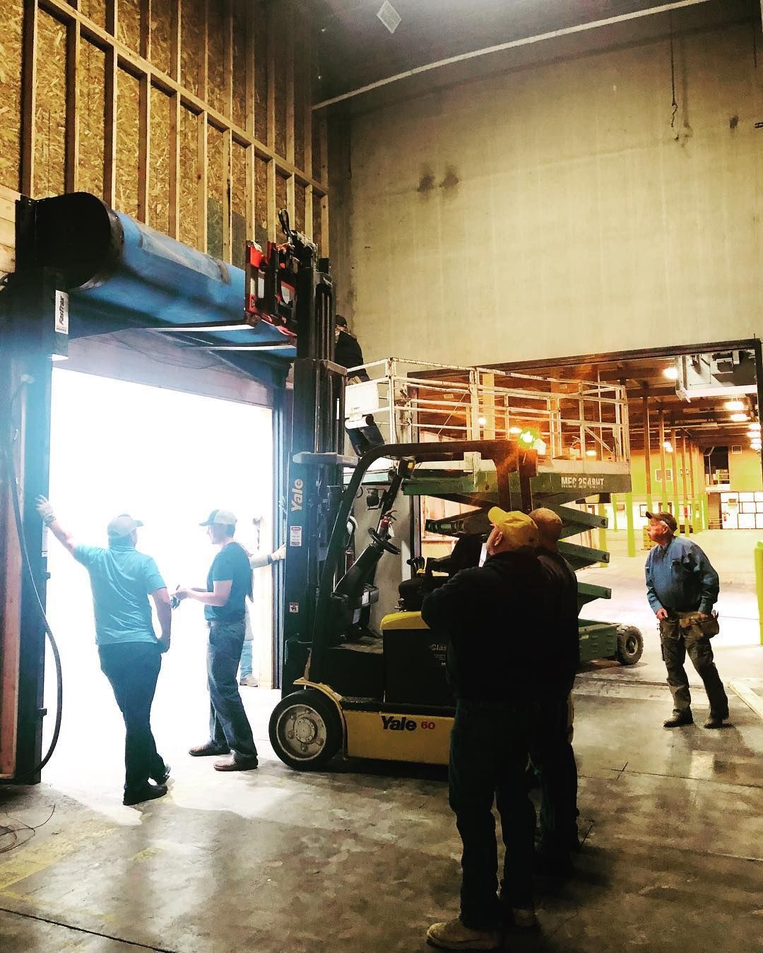 A forklift helping to unload pallets at the loading dock.