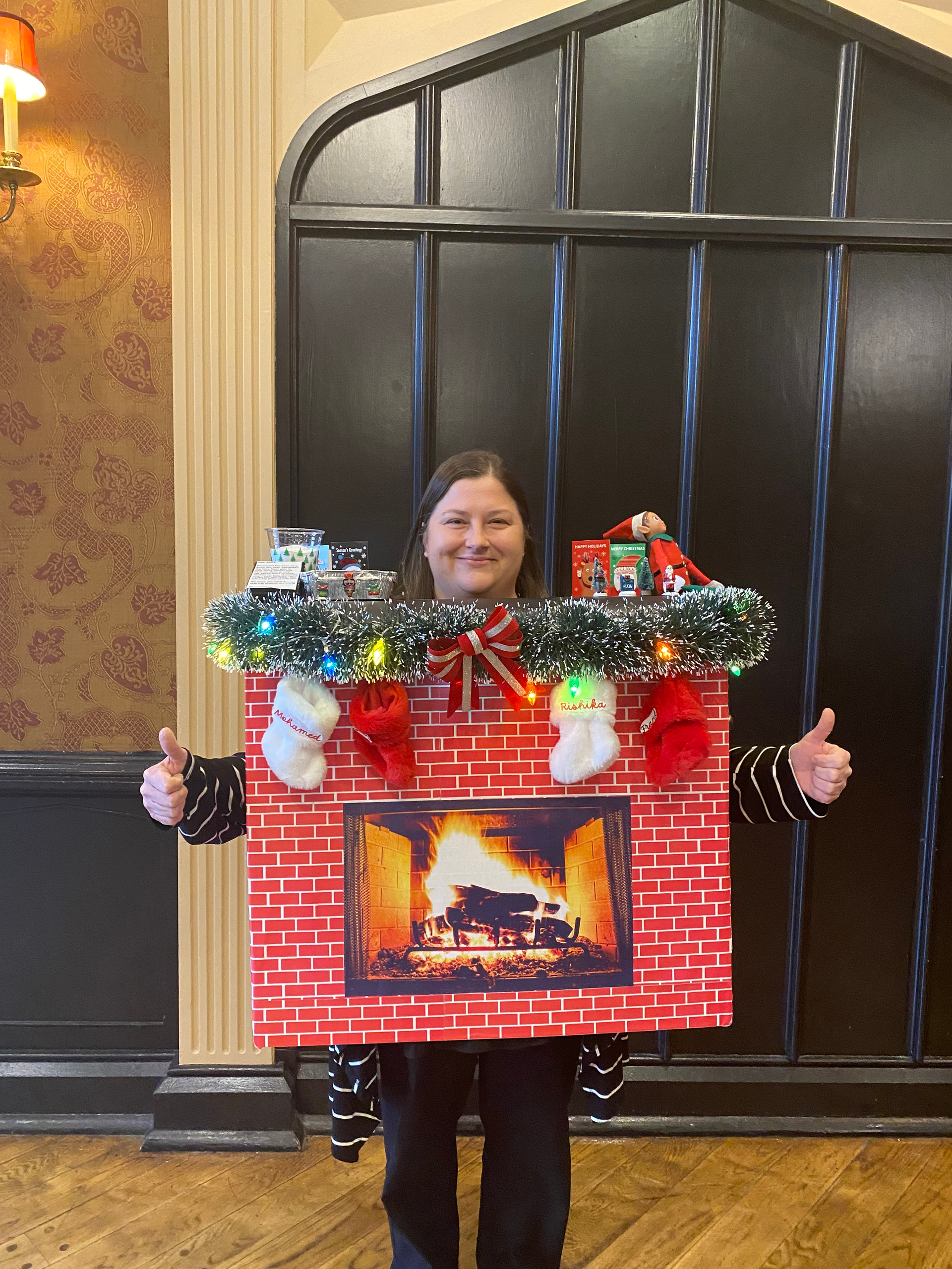 A woman is wearing a fireplace costume with Christmas decorations