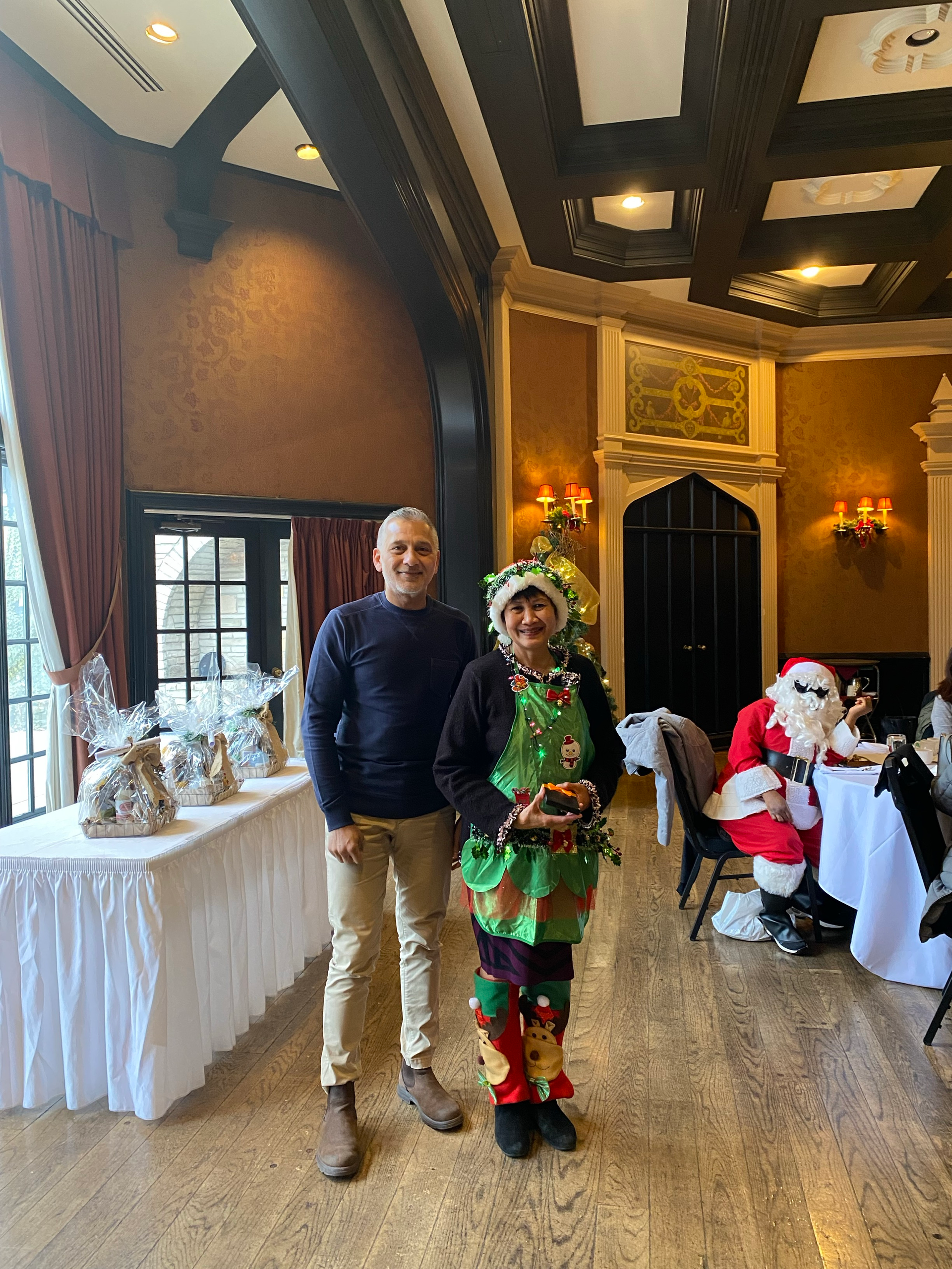 A man and a woman are standing next to each other in a room with Santa in the background