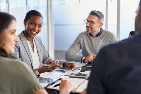 A group of people are sitting around a table having a meeting.