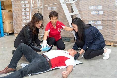 A small group of people clustered around a man lying on the ground