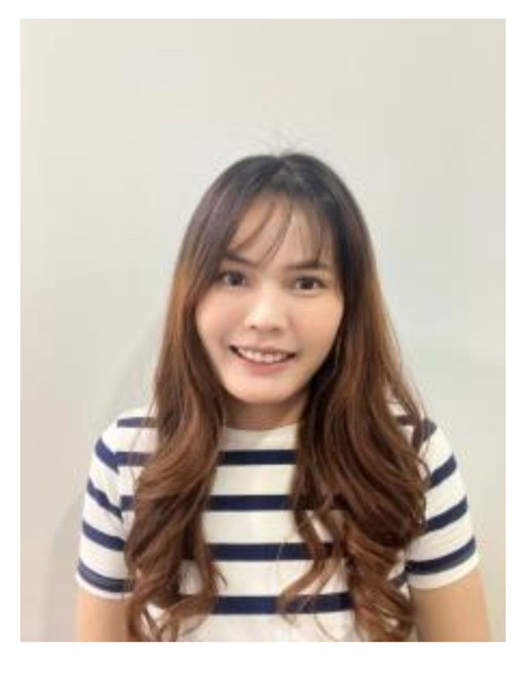 Woman with long, wavy brown hair smiles while wearing a striped shirt against a white background.
