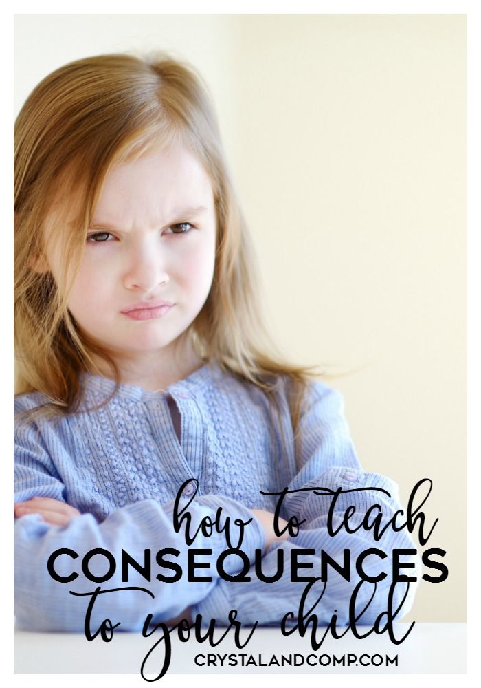 A little girl is sitting at a table with her arms crossed.