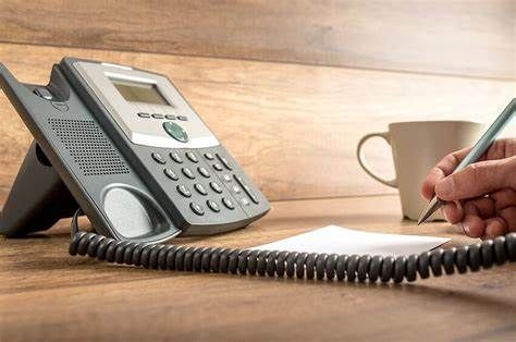 A vintage telephone sits elegantly on the polished wooden table