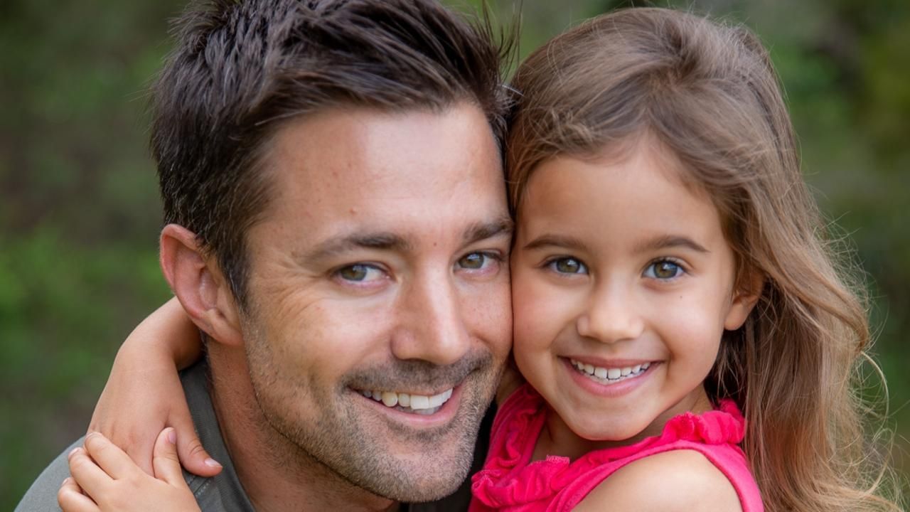 A man is holding a little girl in his arms.