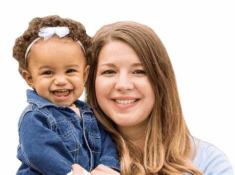 A woman is holding a little girl in her arms.