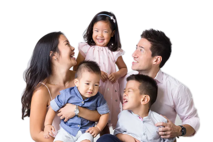 A family is posing for a picture together on a white background.