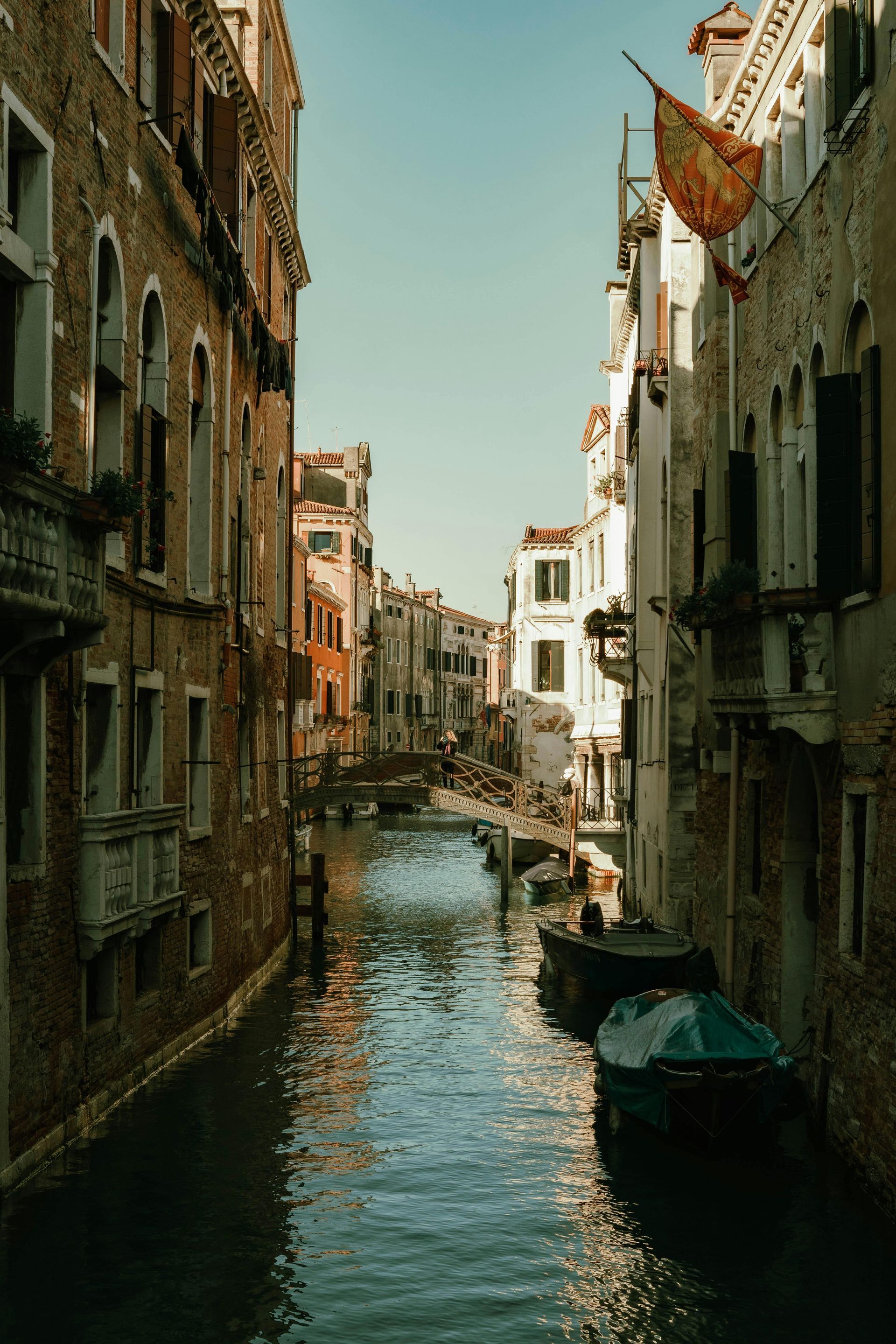 A canal in venice between two buildings with boats in it.