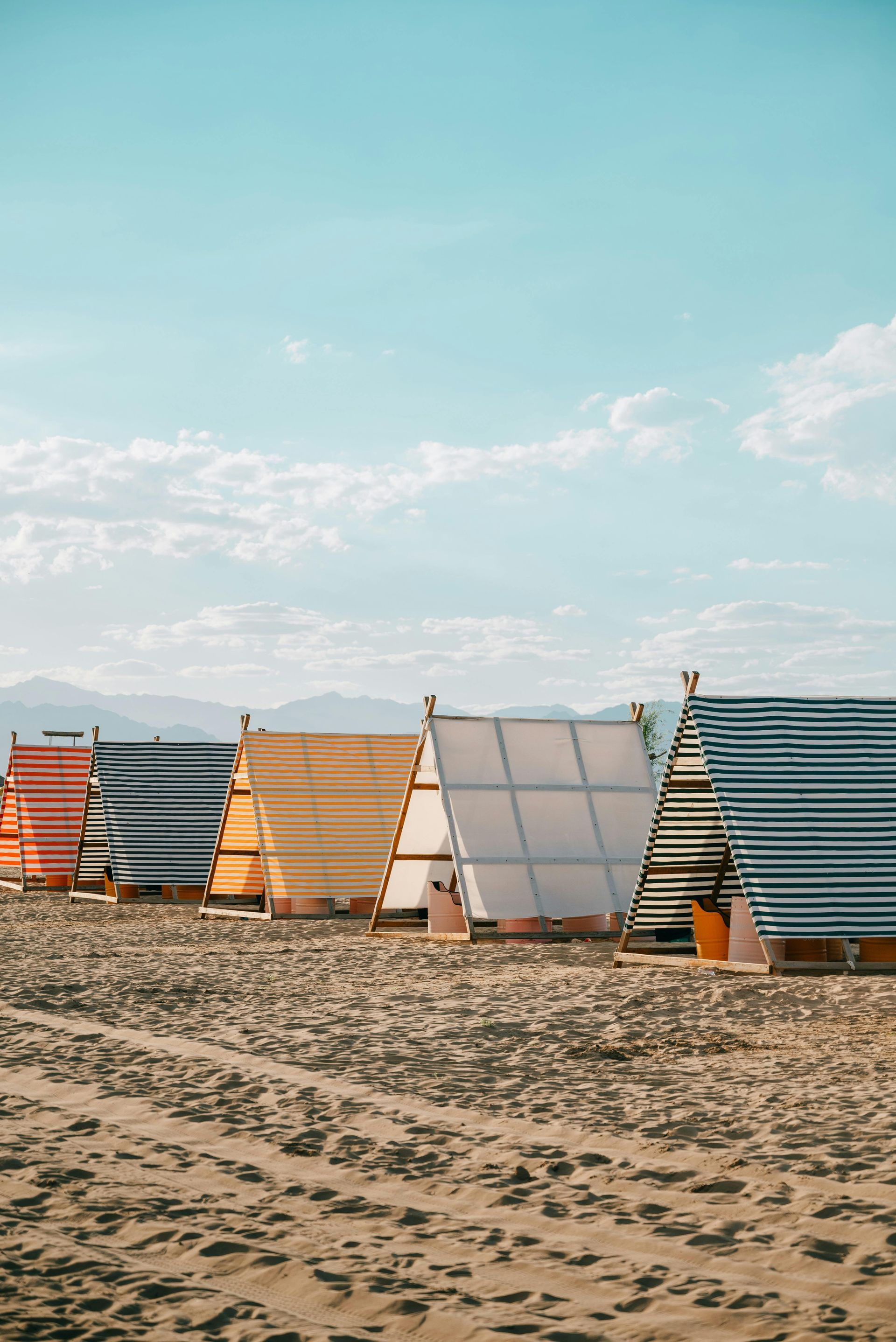 A row of small houses on a sandy beach.