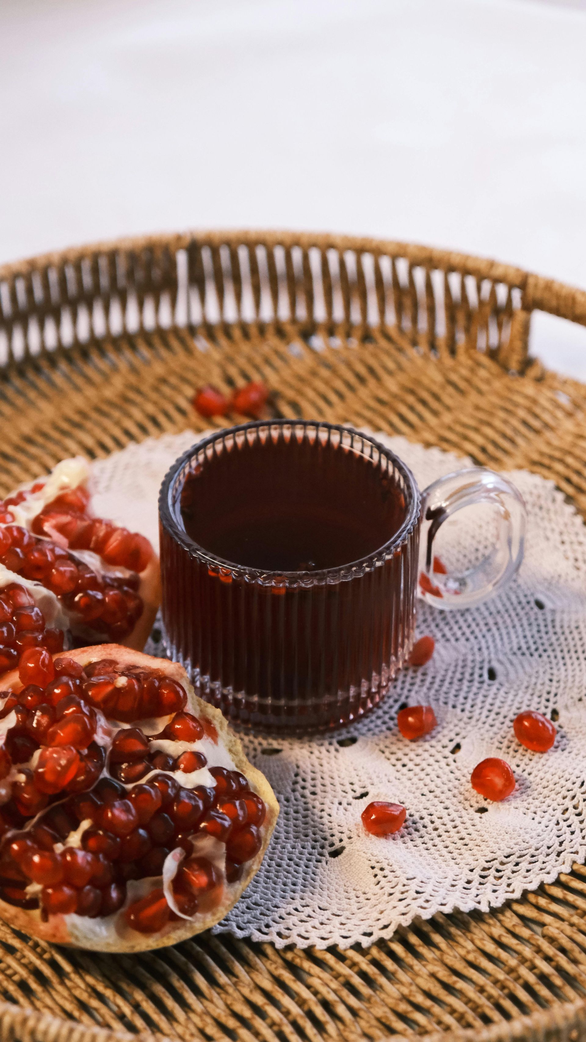 A tray with a cup of tea and pomegranate seeds on it.