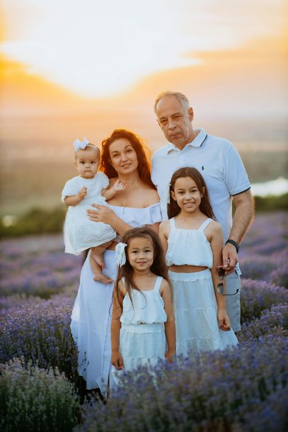 A family is posing for a picture in a lavender field.