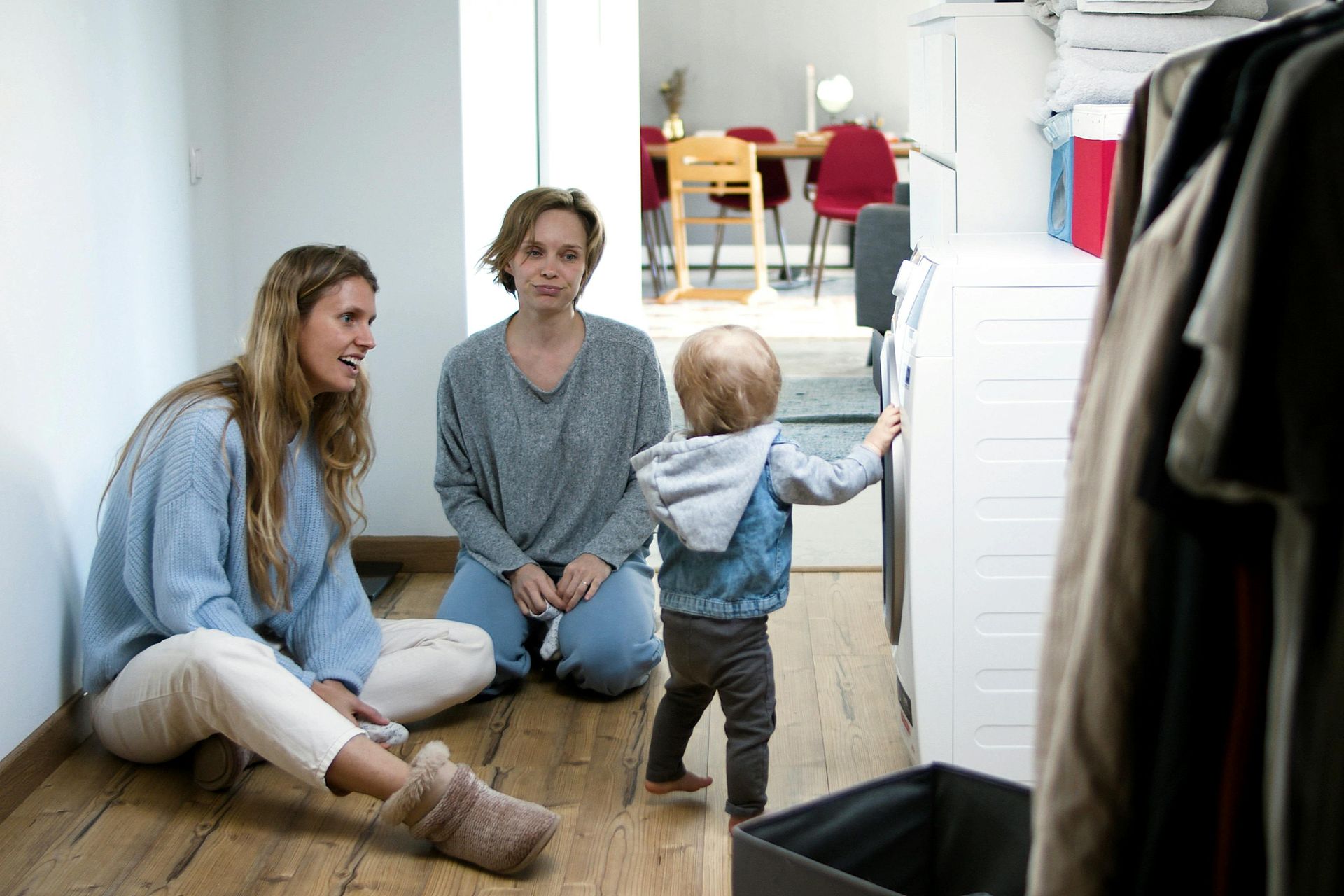 Two women and a toddler by a washing machine, in a laundry room. with Nanny from the A Nanny Australian Nanny Agency