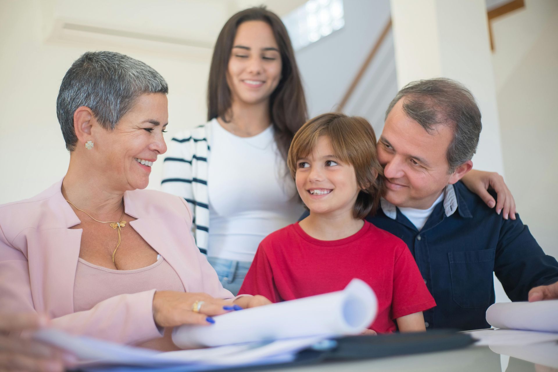 A family is sitting at a table looking at papers.