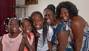 A group of women are posing for a picture together in a living room.