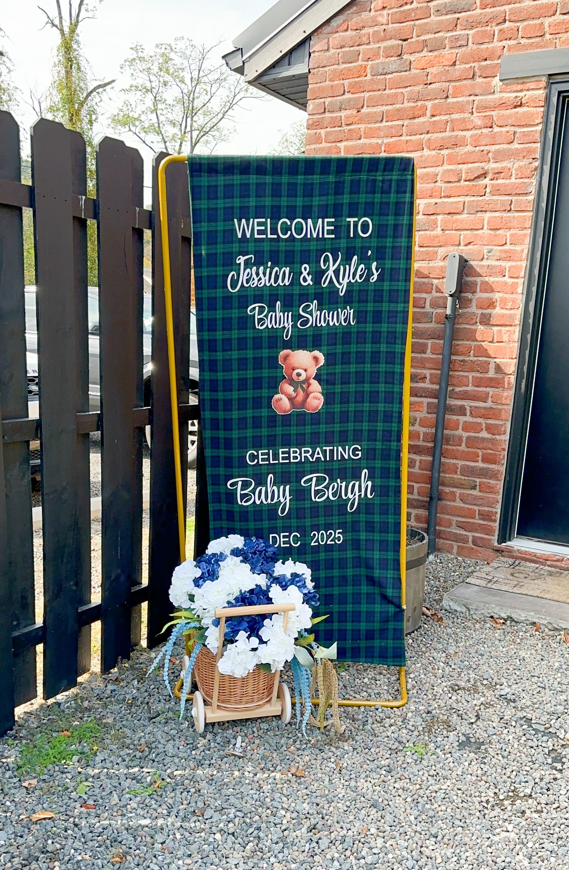 A baby shower sign welcomes guests with a teddy bear and floral decorations.