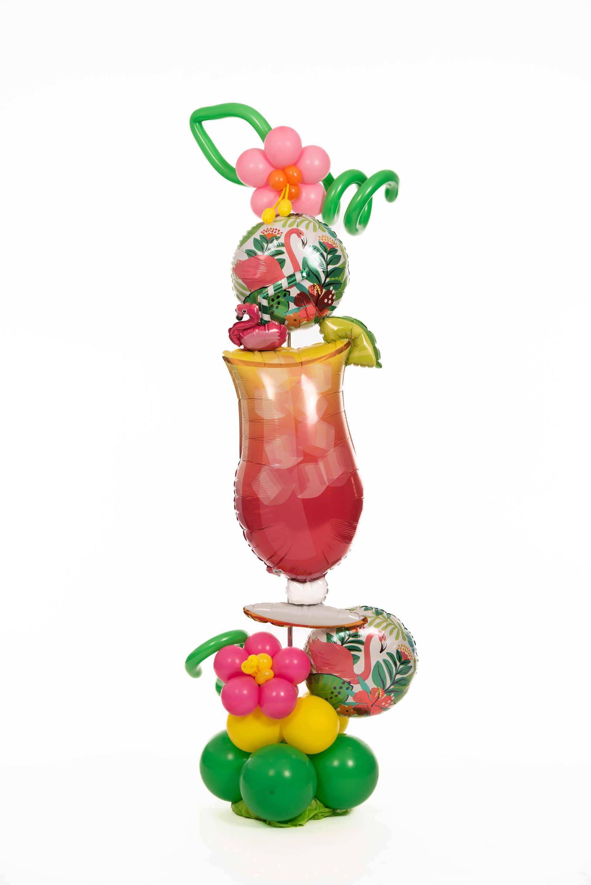 Balloon sculpture of a tropical cocktail, including flowers, flamingos, and green accents on a white background.