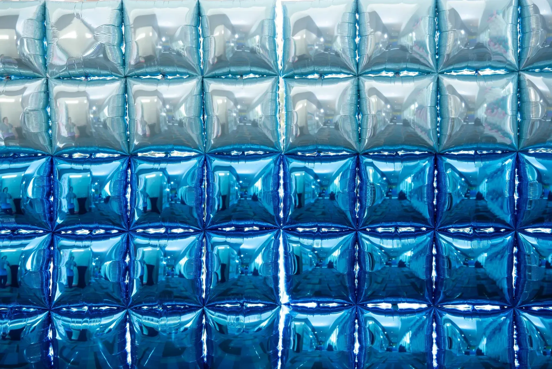 Blue gradient of shiny, square tiles reflecting light.