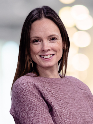 A man is carrying a woman on his back and kissing her on the cheek.
