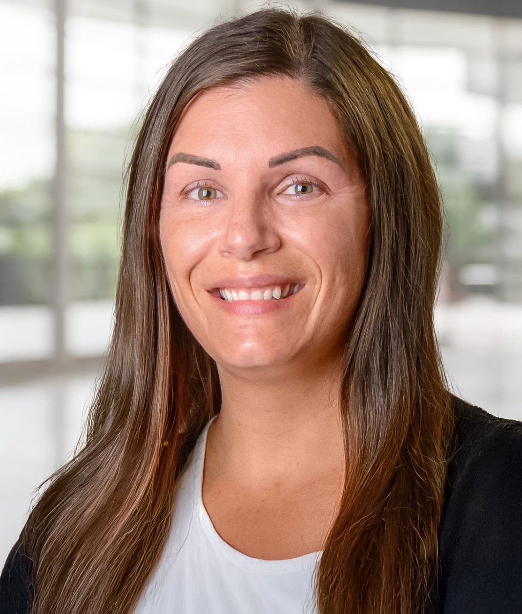 A man is carrying a woman on his back and kissing her on the cheek.