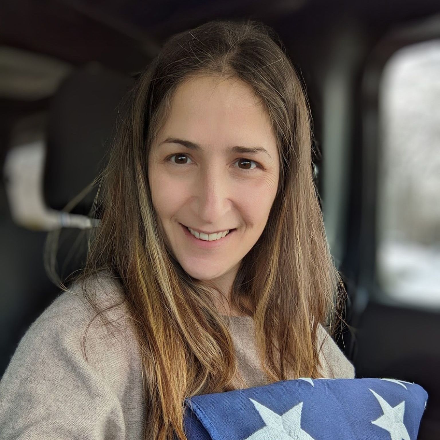 A man is carrying a woman on his back and kissing her on the cheek.