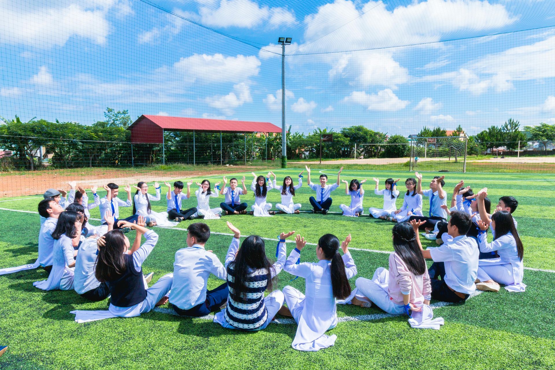A group of people are sitting in a circle on a field.