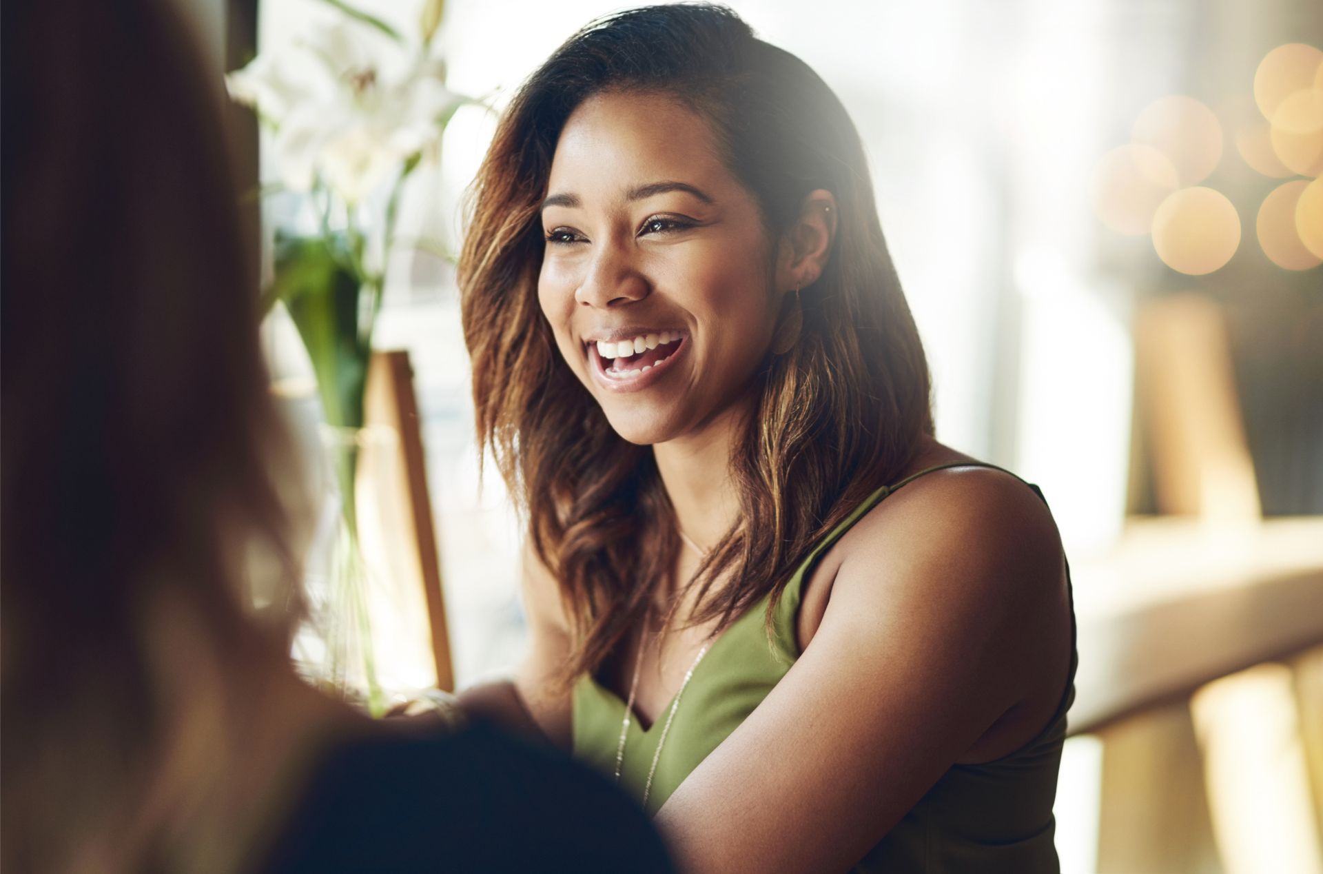 A woman is covering her face with her hands.