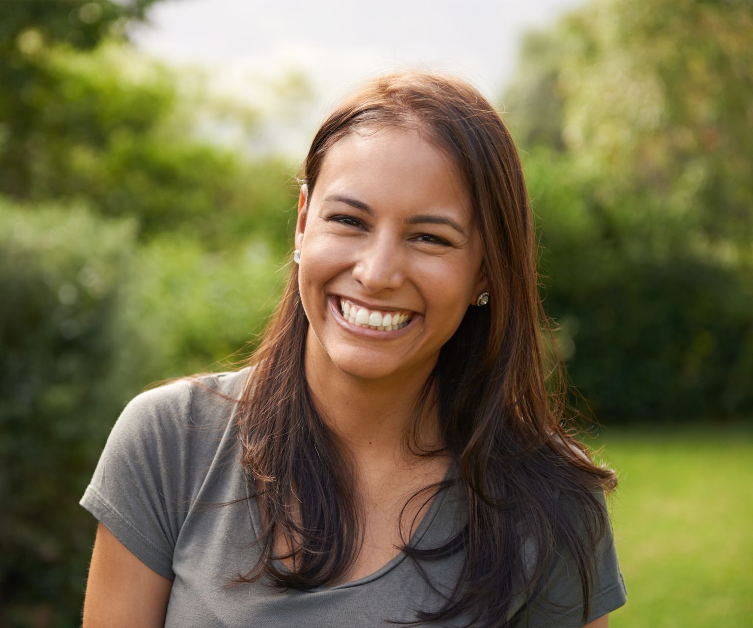 A woman is covering her face with her hands.