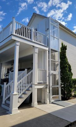 A white house with a stair lift attached to the side of it.