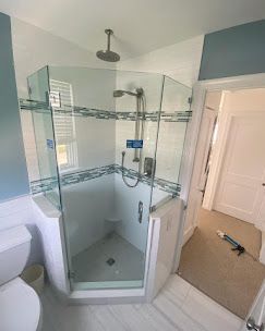 A bathroom with a shower , toilet , and window.