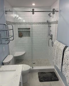A bathroom with a toilet , sink , shower and sliding glass door.