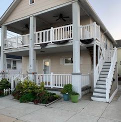 A large house with a large porch and stairs leading up to it.