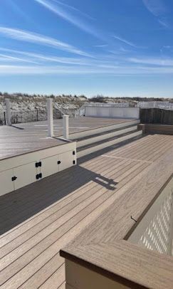 A wooden deck with stairs leading up to it and a swimming pool.