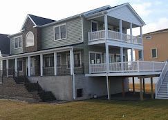 A large house with a large deck and stairs.