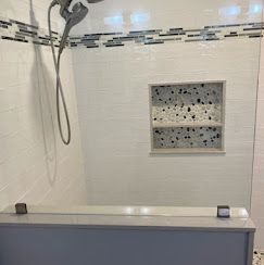 A bathroom with a shower , tub , and mirror.