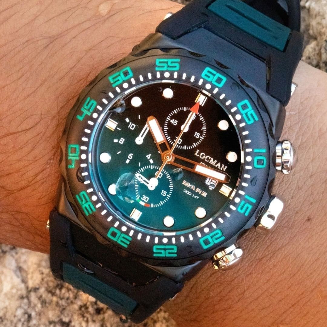 Primo piano di un orologio Locman nero con lunetta e quadrante verdi, indossato al polso.