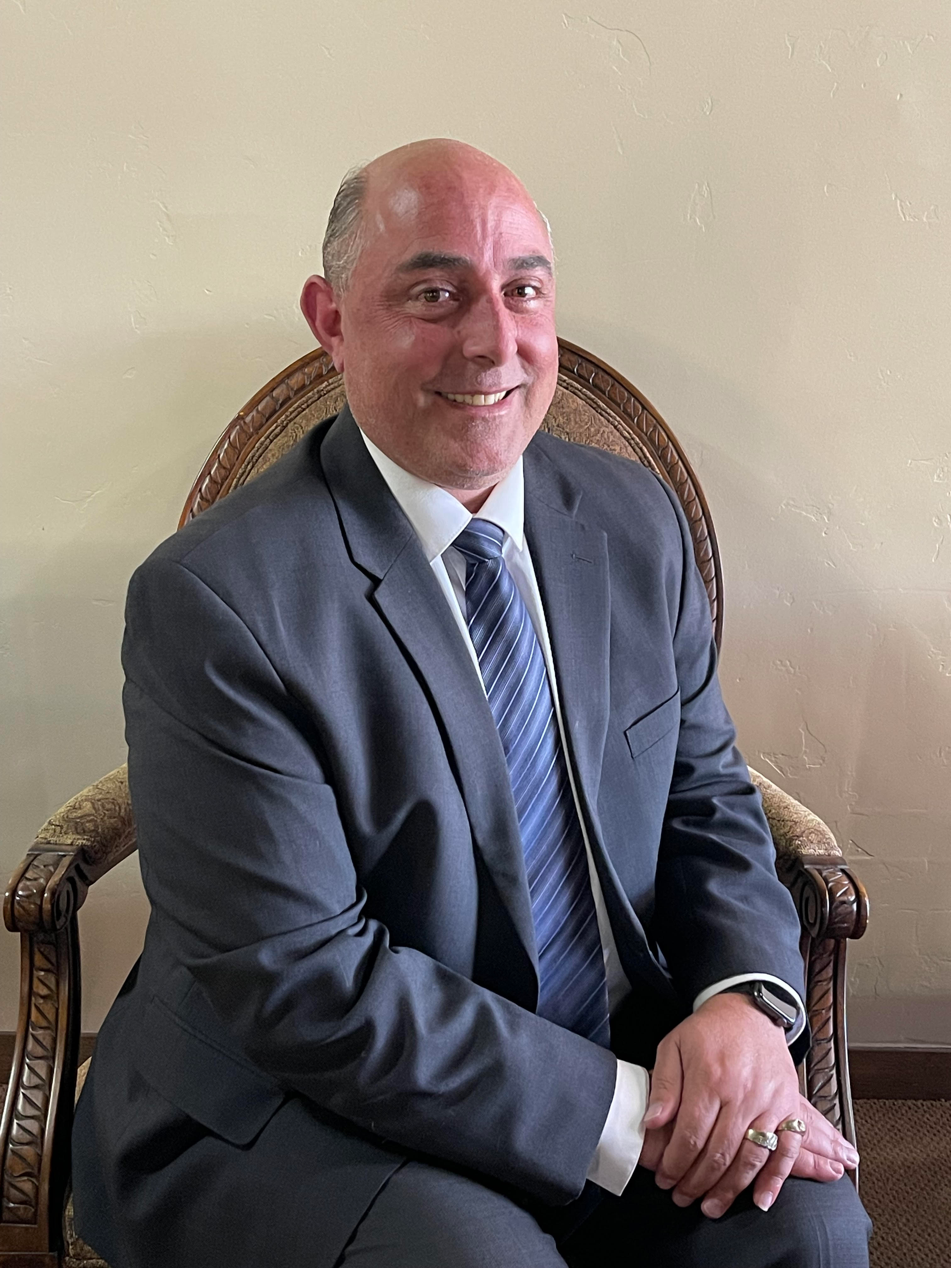 a man in a suit and tie sits in a chair