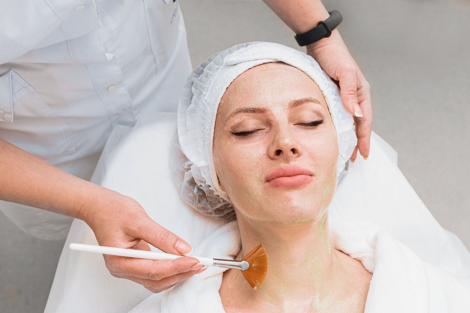 A woman is getting a facial treatment at a beauty salon.
