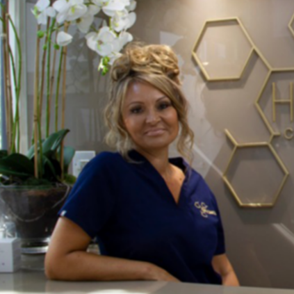A woman is sitting at a counter in front of a sign that says hifu