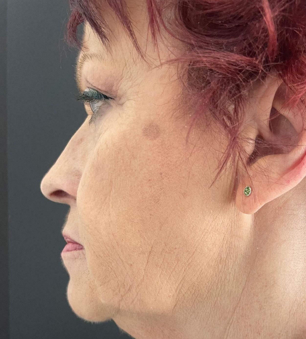 A close up of a woman 's face with red hair and earrings.