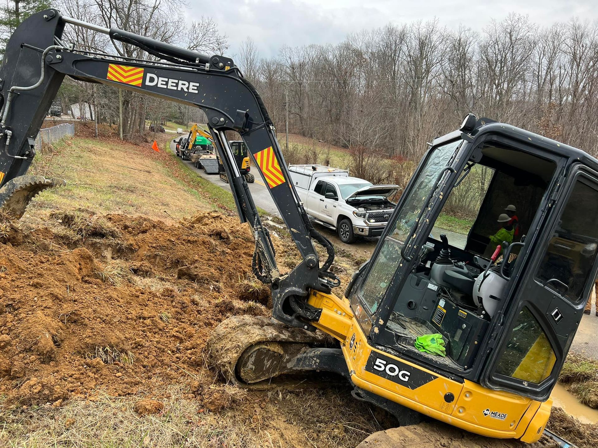 A small excavator is sitting on top of a pile of dirt.