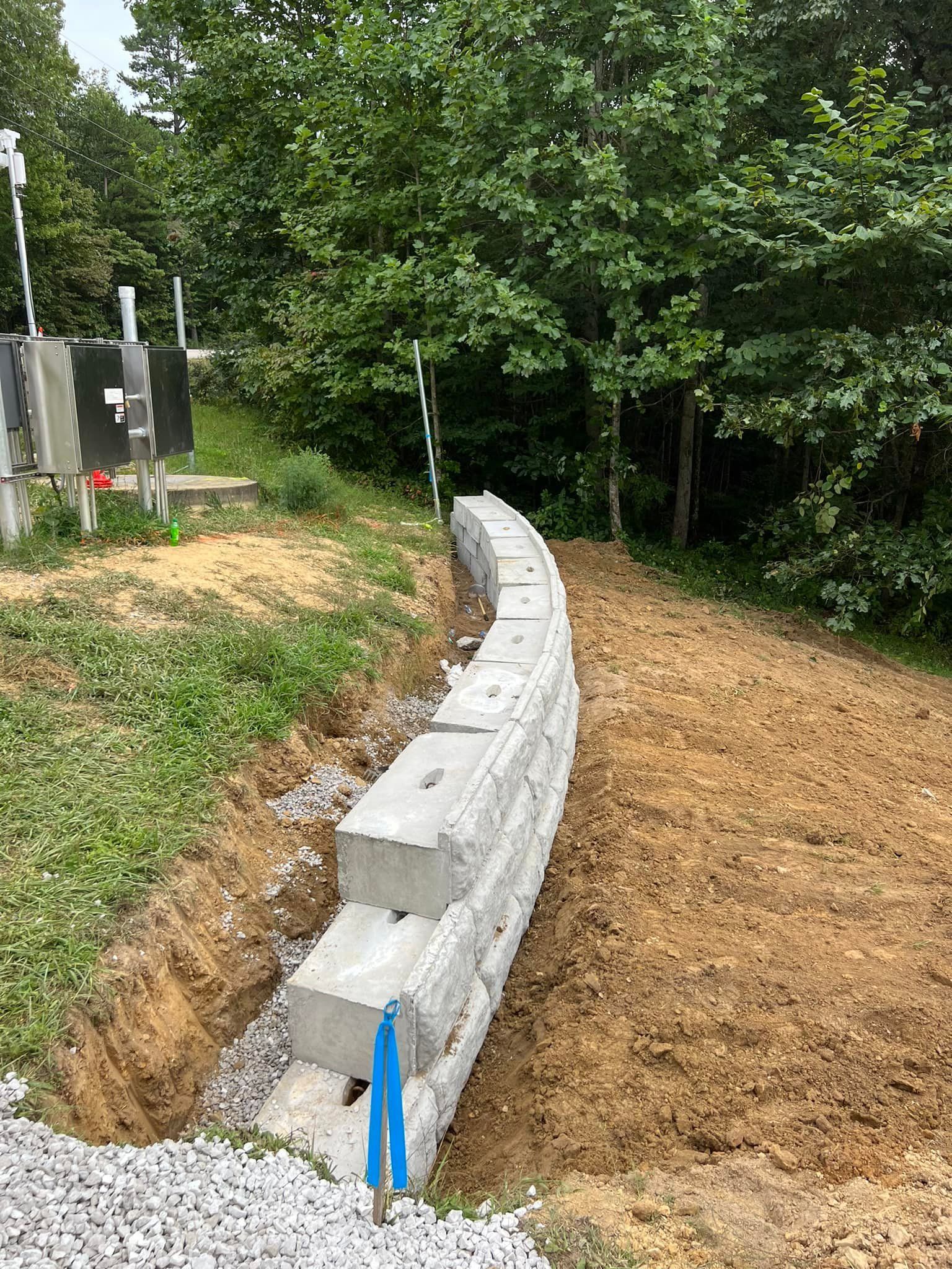 A concrete wall is being built in the middle of a dirt field.