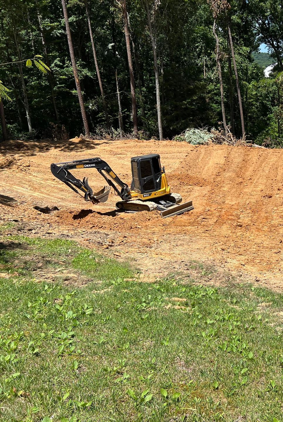 Three construction workers are posing for a picture on a sidewalk.