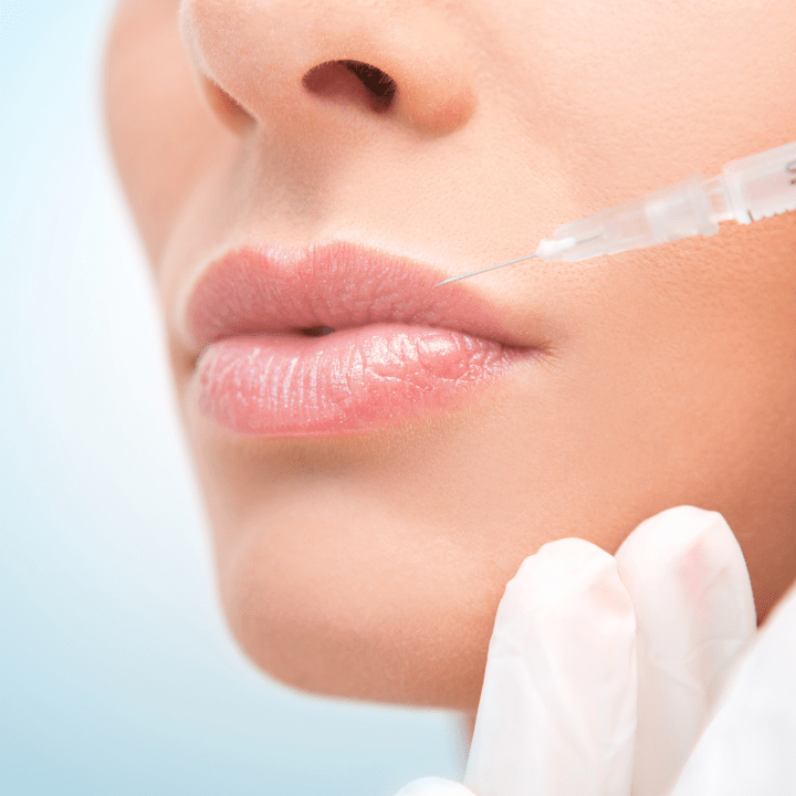 A woman is getting a botox injection in her lips.