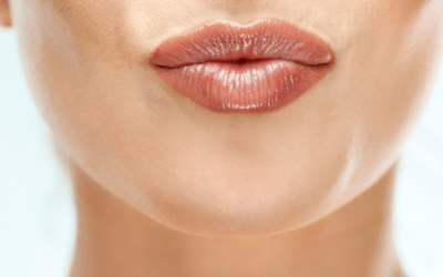 A close up of a woman 's lips blowing a kiss.