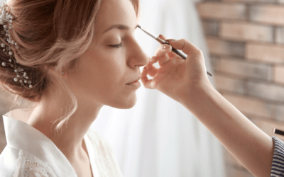 A woman is getting her makeup done by a makeup artist.